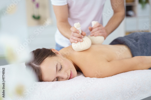 eine entspannende massage mit kräuterstempeln