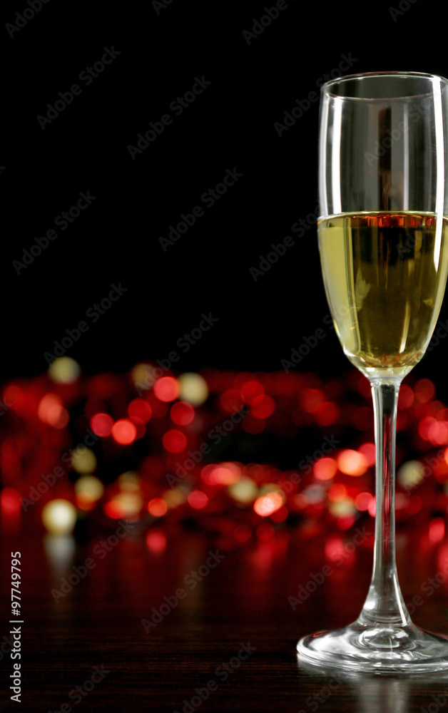 A glass of champagne with bokeh on dark background A glass of champagne with bokeh on dark background
