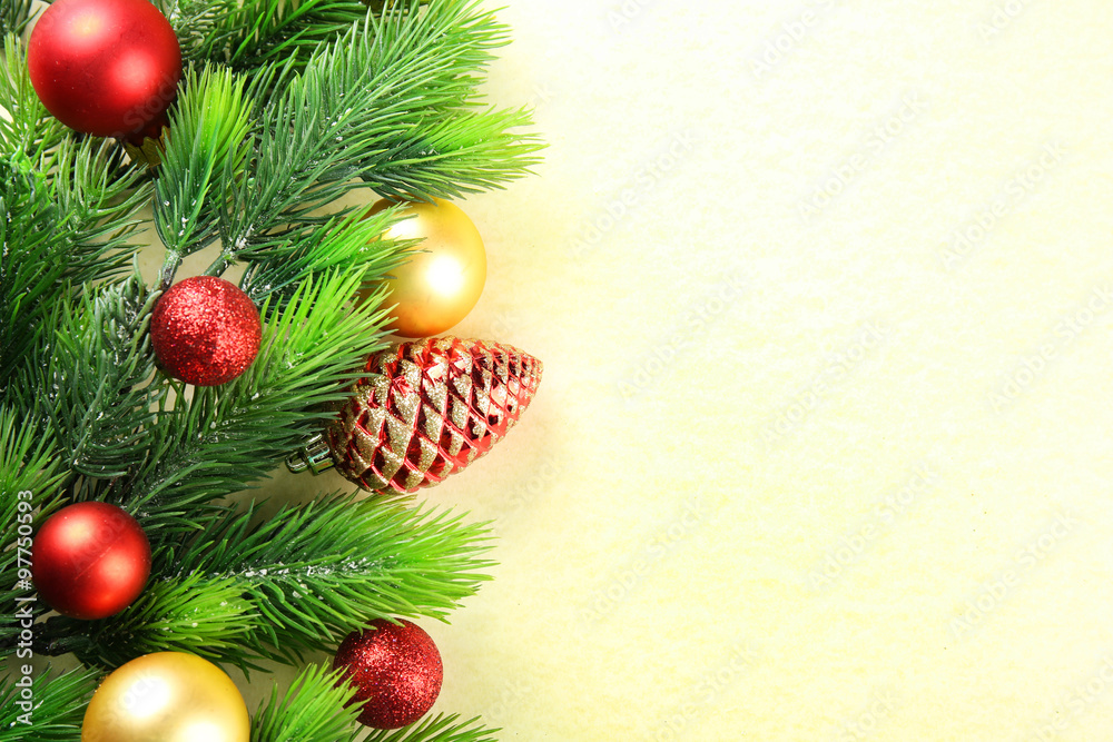 Christmas fir tree branches with toys on paper background Christmas fir tree branches with toys on paper background