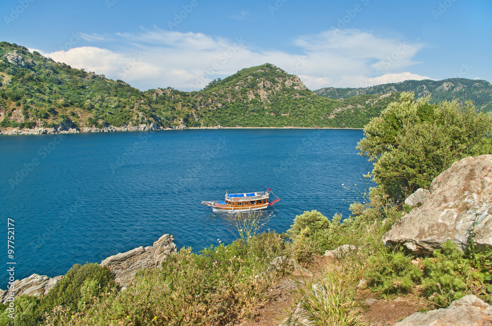 view of small tourist boat in bay from cliff