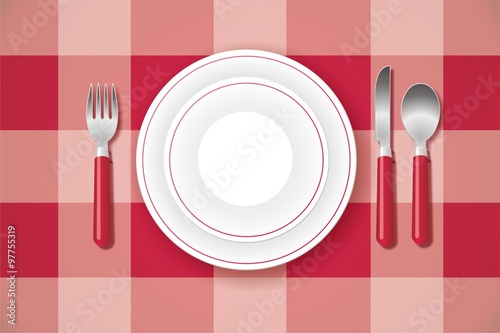 Platos y cubiertos sobre mantel de cuadros rojos