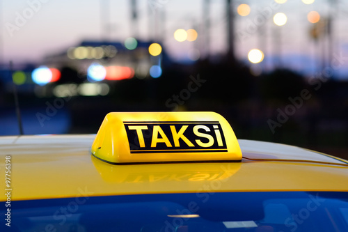 Macro view of yellow turkish taxi sign on car at night.