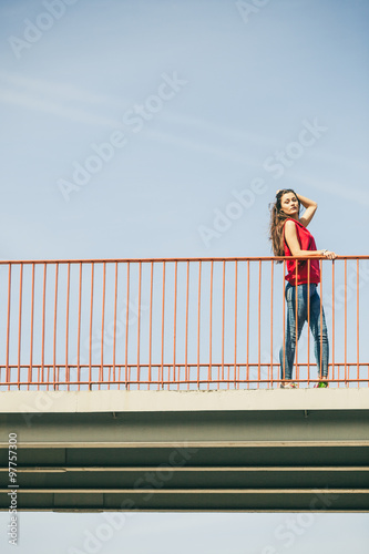 Girl on bridge in city.
