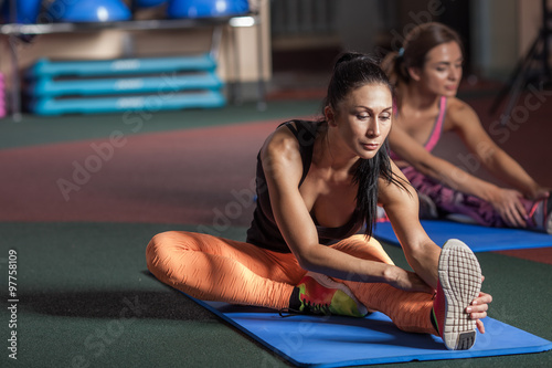 Women stretching legs in sports club