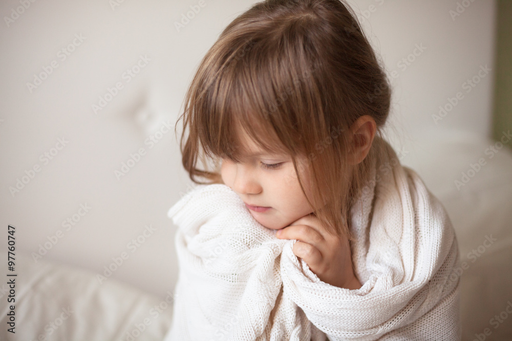 girl wrapped in a light blanket, light background