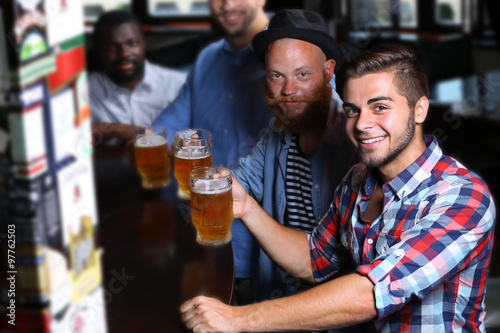 Young men drinking beer in pub