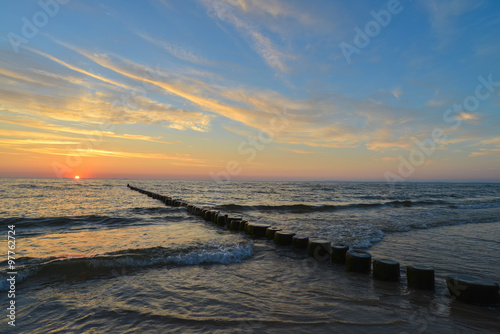 Fototapeta Naklejka Na Ścianę i Meble -  Ostsee mit Buhnen, blauer Himmel kurz vor Sonnenaufgang