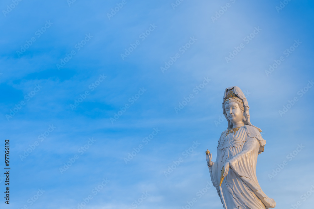 The statue of Guanyin with blue sky. Chinese goddess statue. Places of Worship