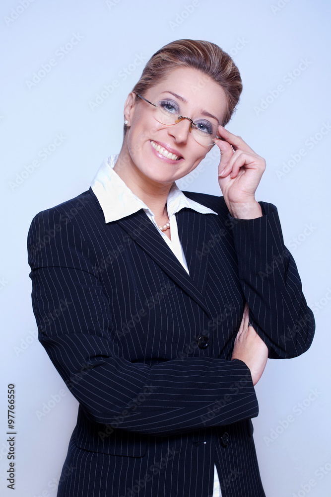 Businesswoman in a black suit with crossed arms wearing glasses. Businesswoman in a black suit with crossed arms wearing glasses.