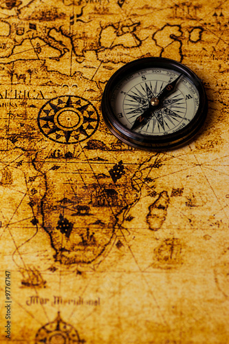 vintage lifestyle concept: retro compass on antique world map