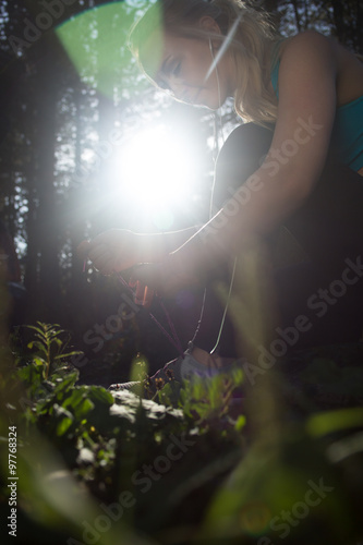 Sporty woman tying her shoelace on a sunny day