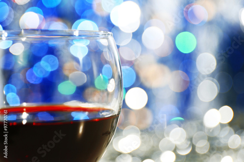 A glass of red wine on blurred lighted background
