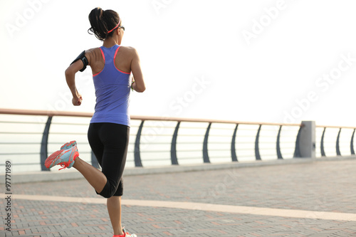 young woman runner athlete running at seaside © lzf