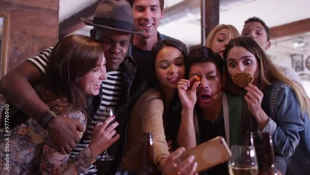 Multi ethnic group of fun loving young hipster friends taking a goofy selfie together at party Multi ethnic group of fun loving young hipster friends taking a goofy selfie together at party