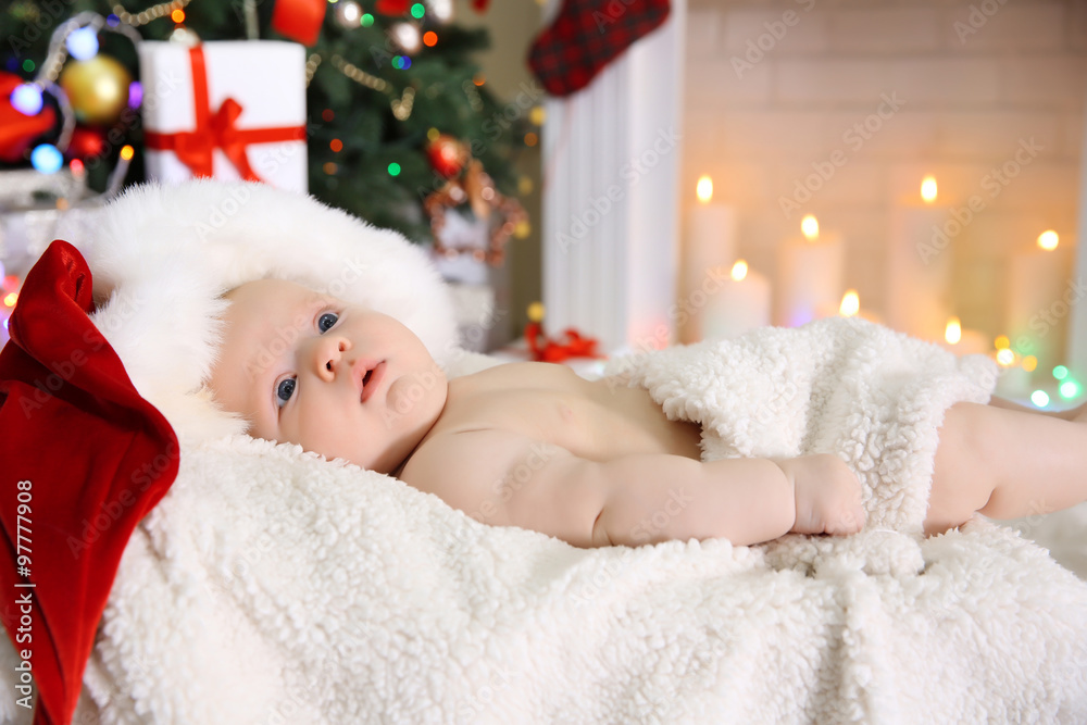 Cute naked baby in red hat on the warm blanket, close up