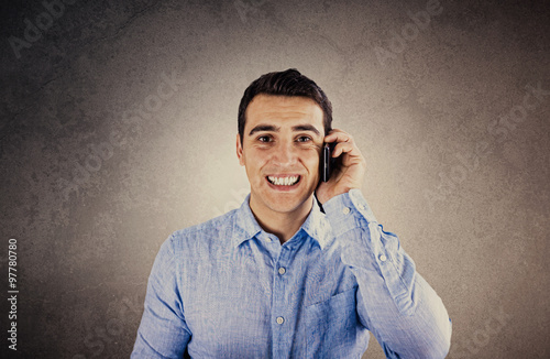 Fake smile.Young student man smiles falsely over white background.Worker talking to phone with a fake smile, forced smile.