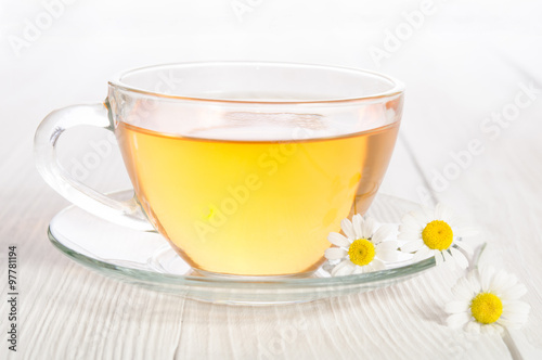 Cup of medicinal chamomile tea on the wooden table