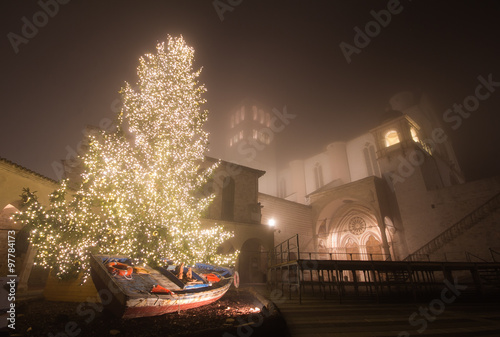 Basilica di San Francesco con albero di Natale immersa nella nebbia photo