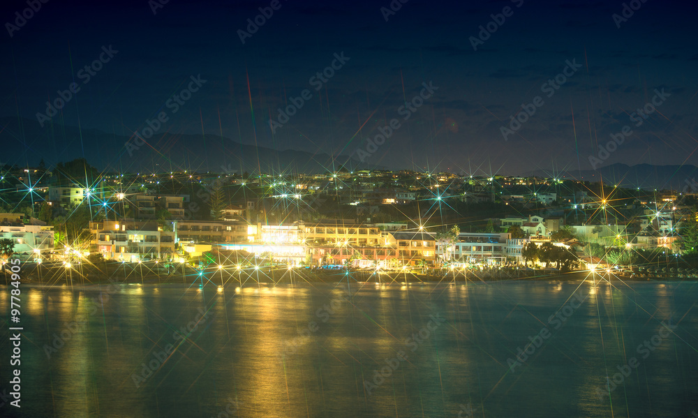 Night view of coastline with houses.