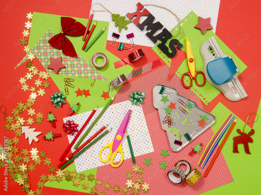 Arts and craft supplies for Christmas. Red and green color paper, pencils, different washi tapes, craft scissors, festive Xmas supplies for decoration.