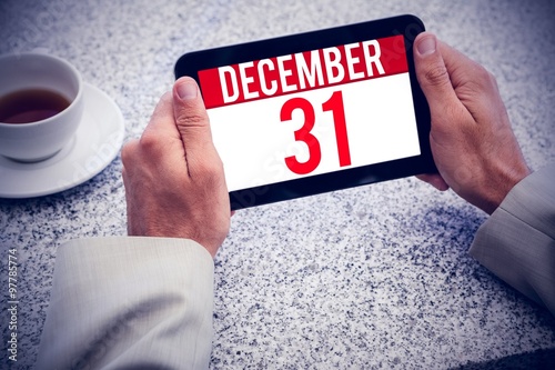 Composite image of businessman holding small tablet at table