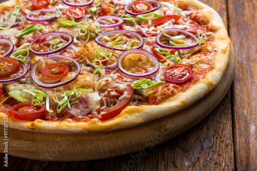 Delicious pizza with onions, bacon and cherry tomato