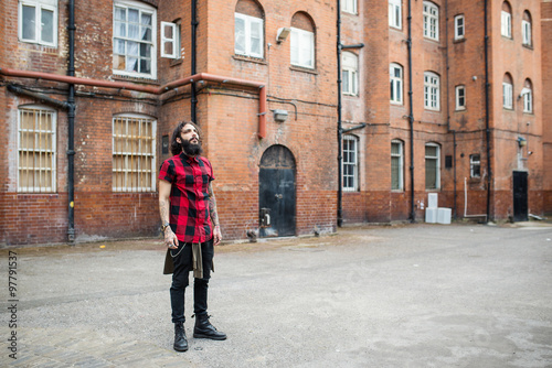 Full body portrait of young tattooed man standing in Shoreditch borough. London.