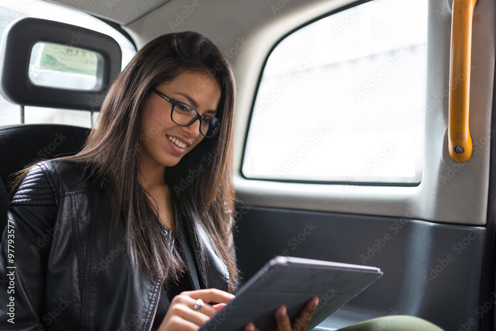 Smiling portrait of young mixed race businesswoman inside a taxi in London. Smiling portrait of young mixed race businesswoman inside a taxi in London.
