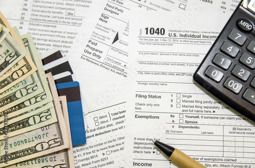 Heap of tax form, credit cards, the calculator, a ball pen and money