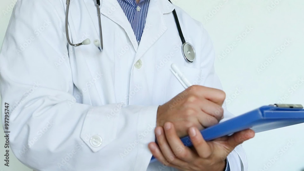 medico con stetoscopio, camice e cartellina che scrive su cartellina la diagnosi dopo un'analisi