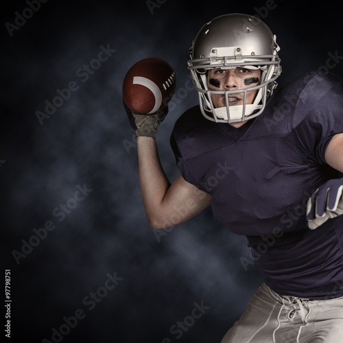 American football player in uniform throwing ball