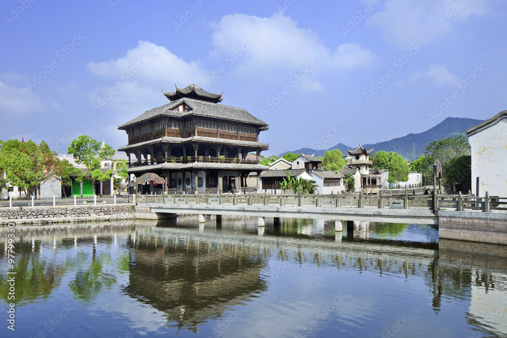 Ancient wooden house and bridge reflected in a tranquil canal, Hengdian, China Ancient wooden house and bridge reflected in a tranquil canal, Hengdian, China