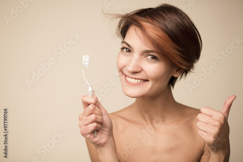 Bella ragazza mentre lava i denti photo