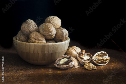 Bowl de madera con nueces sobre un fondo negro photo