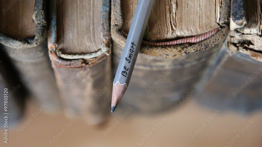 Be smart - inscription on a gray pencil and old books Be smart - inscription on a gray pencil and old books