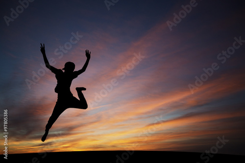 silhouetted boy jumping in sunset for fun