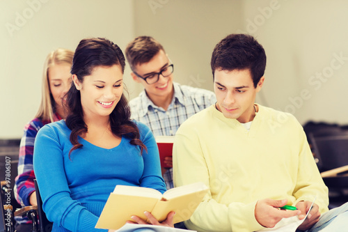 group of smiling students with notebooks