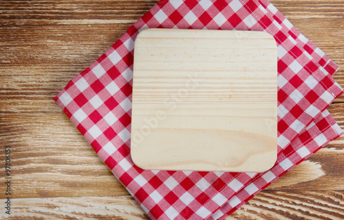 Wooden board on red cloth background.