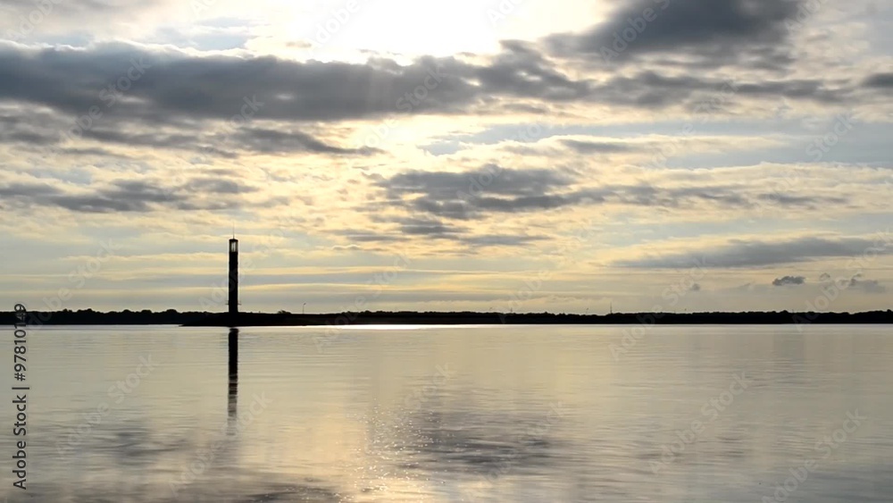 Time lapse of clouds at dawn with lighthouse