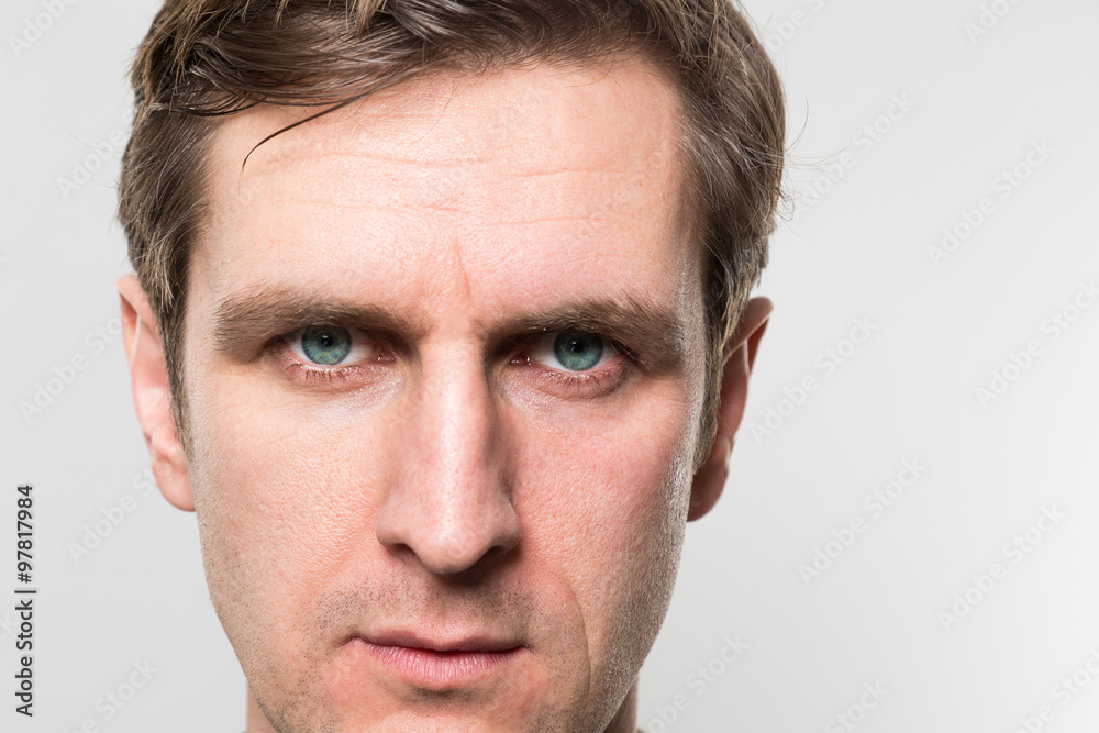 Obraz premium Close up of a blond-haired european businessman with a straight face to the camera in front of a gradient background