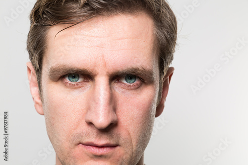 Close up of a blond-haired european businessman with a straight face to the camera in front of a gradient background