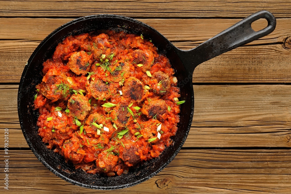 Homemade yummy meatballs in tomato sauce in cast iron pan Homemade yummy meatballs in tomato sauce in cast iron pan