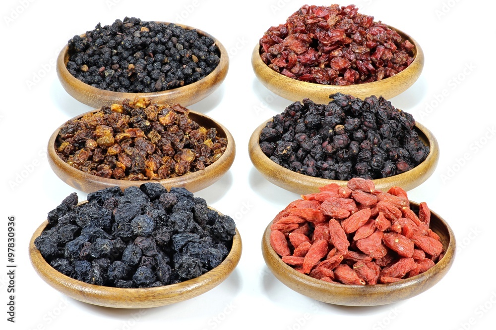 Auswahl getrockneter Beeren (Aronia, Sanddorn, Goji, Berberitzen, Schisandra, Hollunder) in Olivenholzschalen isoliert auf weißem Hintergrund Auswahl getrockneter Beeren (Aronia, Sanddorn, Goji, Berberitzen, Schisandra, Hollunder) in Olivenholzschalen isoliert auf weißem Hintergrund