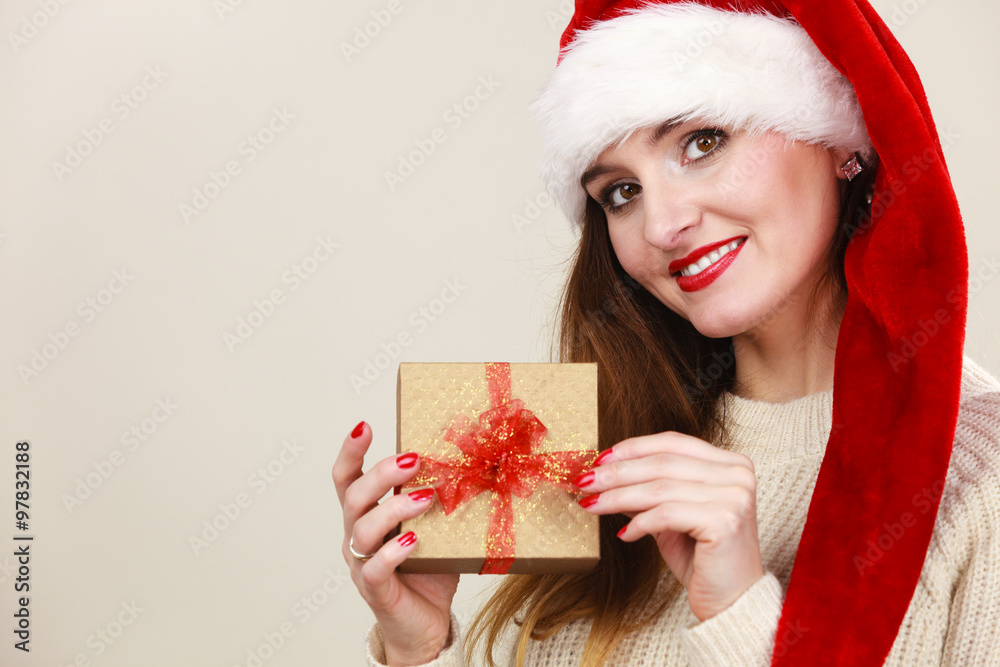 Woman in santa helper hat holds gift box Woman in santa helper hat holds gift box