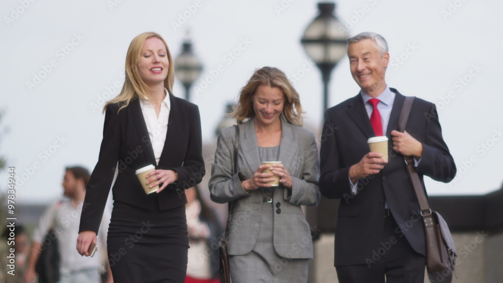 Happy businesspeople talking and walking through a city Happy businesspeople talking and walking through a city