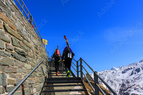 Skiers going upstairs at the snow mountain background
