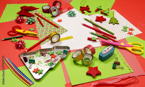 Arts and craft supplies for Christmas. Red and green color paper, pencils, different washi tapes, craft scissors, festive Xmas supplies for decoration.