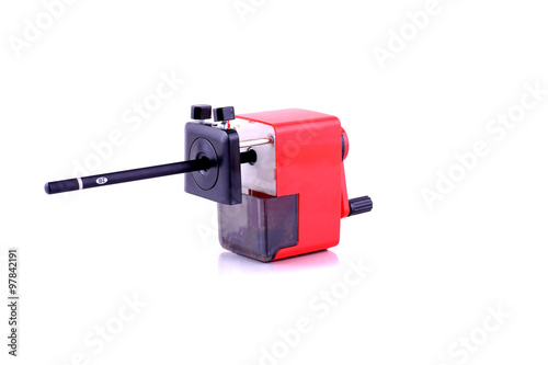 red rotary pencil sharpener with black pencil isolated on white background
