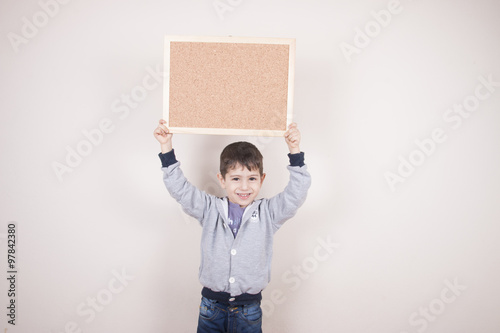 çocuk boş ilan panosunu havaya kaldırıyor photo