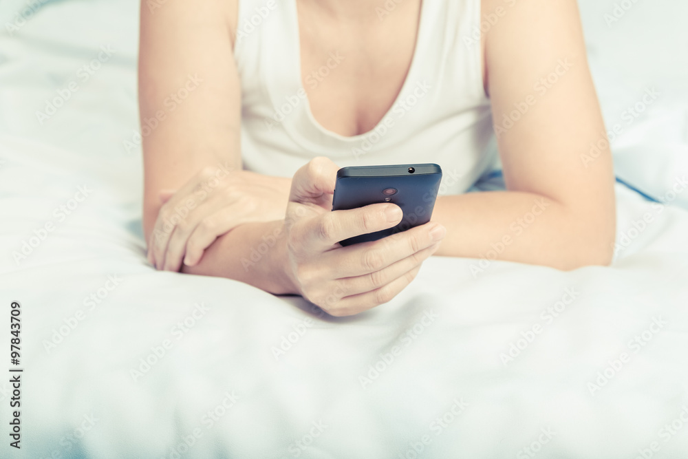Young caucasian woman on the bed with smartphone Young caucasian woman on the bed with smartphone
